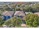 Aerial view of two-story house with gray roof and blue siding, surrounded by trees and other homes at 9026 Dry Creek Ln, Orlando, FL 32832