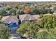 Aerial view of a two-story house with gray roof and blue siding, surrounded by trees and other homes at 9026 Dry Creek Ln, Orlando, FL 32832