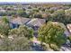 Aerial view of a house with gray roof and blue siding, surrounded by lush trees and other houses at 9026 Dry Creek Ln, Orlando, FL 32832