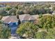 Aerial view of a two-story house with a gray roof and blue siding, surrounded by trees and other homes at 9026 Dry Creek Ln, Orlando, FL 32832