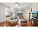 Cozy living room with hardwood floors, comfy seating, and large TV at 9026 Dry Creek Ln, Orlando, FL 32832