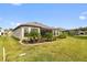 Spacious backyard with screened patio, lush landscaping, and grassy area at 972 Ladera Ranch Rd, Kissimmee, FL 34759