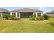 Landscaped backyard with spacious lawn and screened-in porch at 972 Ladera Ranch Rd, Kissimmee, FL 34759