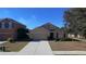 Tan one-story house with a two-car garage and landscaped yard at 102 Lake Tracy Ct, Haines City, FL 33844