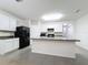 Modern kitchen with white cabinets, island, and stainless steel appliances at 102 Lake Tracy Ct, Haines City, FL 33844