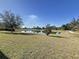Peaceful pond view with lush green grass and mature trees at 102 Lake Tracy Ct, Haines City, FL 33844
