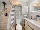 Updated bathroom with a shower/tub combo, white vanity, and stylish gray and white striped shower curtain at 1500 E Oak Leaf Ln, Kissimmee, FL 34744