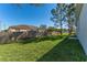 Large backyard with grassy area, wooden fence, and mature trees at 1603 Tench Ct, Kissimmee, FL 34759