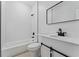 Clean bathroom with white subway tile, a bathtub, and a barn door vanity at 1603 Tench Ct, Kissimmee, FL 34759