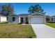 Newly built home with a two-car garage and front yard at 1603 Tench Ct, Kissimmee, FL 34759