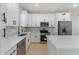 Modern kitchen with white cabinets, stainless steel appliances, and quartz countertops at 1603 Tench Ct, Kissimmee, FL 34759
