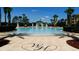 Community pool with surrounding lounge chairs and palm trees at 2778 Almaton Loop # 303, Kissimmee, FL 34747