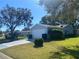 Side view of a light blue vinyl-sided house with a two-car garage, landscaping, and driveway at 5062 El Destino Dr, Leesburg, FL 34748