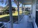 View from a covered porch showing a backyard with grass, trees, and neighboring homes at 5062 El Destino Dr, Leesburg, FL 34748
