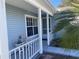 Front porch with white railings, a side view of the house entrance, and landscaping at 5062 El Destino Dr, Leesburg, FL 34748