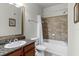Bathroom with tub, shower, granite countertop, and wood cabinet at 902 Charo Pkwy # 636, Davenport, FL 33897