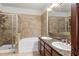 Bathroom with double vanity, granite countertop, soaking tub, and shower at 902 Charo Pkwy # 636, Davenport, FL 33897