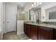 Double vanity bathroom with granite countertop and shower at 7639 Wilmington Loop, Kissimmee, FL 34747