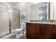Bathroom with shower, toilet, granite countertop, and dark wood cabinets at 7639 Wilmington Loop, Kissimmee, FL 34747