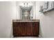 Bathroom with granite countertop, dark wood cabinets, and a large mirror at 7639 Wilmington Loop, Kissimmee, FL 34747