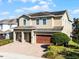 Tan two-story house with brown garage door and neatly landscaped yard at 7639 Wilmington Loop, Kissimmee, FL 34747
