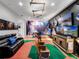 Basement game room features a baseball-themed carpet, big screen TV, and arcade games at 812 Desert Mountain Ct, Reunion, FL 34747