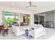 Relaxing outdoor patio with white furniture and a view of lush greenery at 812 Desert Mountain Ct, Reunion, FL 34747
