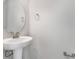 Small bathroom with pedestal sink, round mirror, and neutral walls at 1736 Carnelian St, Deland, FL 32720