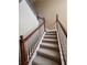 Indoor staircase with a wooden handrail and neutral carpeting at 2018 Gold Spring Cv, Kissimmee, FL 34743