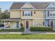 Two-story townhome with covered entry,red door, and landscaped yard at 4012 Santa Maria # 101, Kissimmee, FL 34741