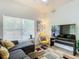 Relaxing living room featuring sectional sofa, accent chair, and large TV at 4012 Santa Maria # 101, Kissimmee, FL 34741