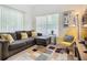 Living room with sectional sofa, yellow accent chair, and patterned rug at 4012 Santa Maria # 101, Kissimmee, FL 34741