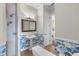 Bathroom with pedestal sink, shower, and blue and white floral wallpaper at 416 Arbor Cir, Celebration, FL 34747