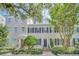 Three-story townhouses with red and black doors, landscaping, and trees at 537 Campus St, Celebration, FL 34747