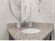Bathroom vanity with granite countertop and round mirror at 825 Desmoines Pl, Kissimmee, FL 34759