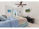 Spacious bedroom with a ceiling fan, large bed, and mounted TV at 825 Desmoines Pl, Kissimmee, FL 34759
