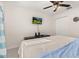 Bedroom with a large bed, ceiling fan, and mounted TV at 825 Desmoines Pl, Kissimmee, FL 34759