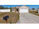 House with a red door, white garage door, and mailbox at 825 Desmoines Pl, Kissimmee, FL 34759
