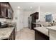 Modern kitchen with dark cabinets, granite counters, and stainless steel appliances at 825 Desmoines Pl, Kissimmee, FL 34759