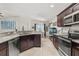 Open kitchen with granite countertops, dark cabinets, and stainless steel appliances at 825 Desmoines Pl, Kissimmee, FL 34759