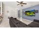 Living room with sectional sofa, ceiling fan, and large TV at 825 Desmoines Pl, Kissimmee, FL 34759