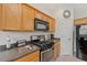 Kitchen boasts stainless steel appliances and wood cabinets at 879 Assembly Ct, Reunion, FL 34747