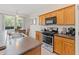Eat-in kitchen with stainless steel appliances and wood cabinets at 879 Assembly Ct, Reunion, FL 34747