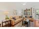 Bright living room with leather sofas, coffee table, and wood floors at 879 Assembly Ct, Reunion, FL 34747