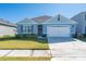 One-story house with blue siding, two-car garage, and well-maintained lawn at 1687 Park Side Ave, Kissimmee, FL 34744