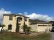 Two-story house with a three-car garage and landscaped yard at 18035 Cadence St, Orlando, FL 32820