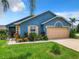 One-story house featuring a beige garage door and neatly landscaped front yard at 204 Fox Loop, Davenport, FL 33837