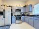 Well-equipped kitchen featuring stainless steel appliances and light-blue cabinets at 204 Fox Loop, Davenport, FL 33837
