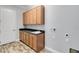 Laundry room with wood cabinets, granite countertop, and tile floor at 2482 Yellow Brick Rd, St Cloud, FL 34772