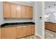 Bright laundry room with ample wood cabinetry and granite counters at 2482 Yellow Brick Rd, St Cloud, FL 34772